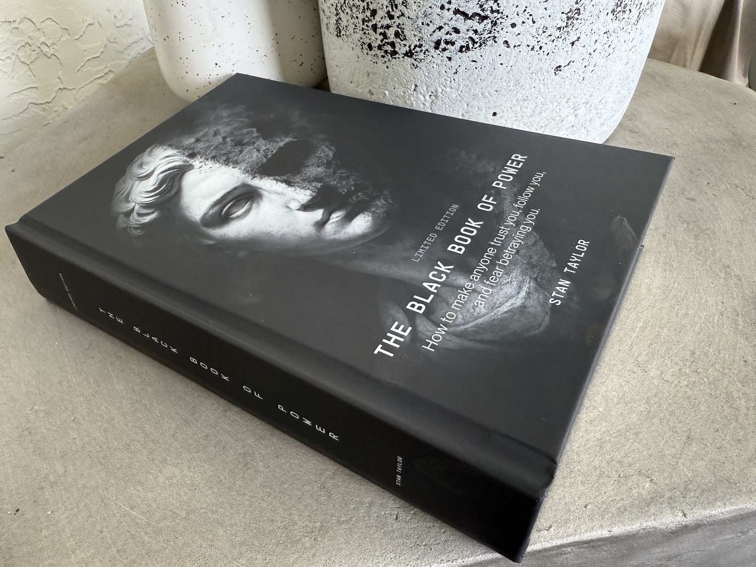 Book titled 'The Black Book of Power' on a surface with a blurred background